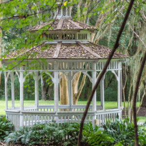 landscapers in niagara - 20 Things to Do to Your Yard - a white gazebo nestled among trees in a landscaped area