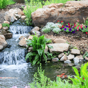 landscapers niagara - 21 Landscaping Ideas That Will Make Your Property Stand Out - a waterfall surrounded by rocks and plants and flowers